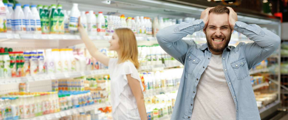 Man holding his head in a grocery store