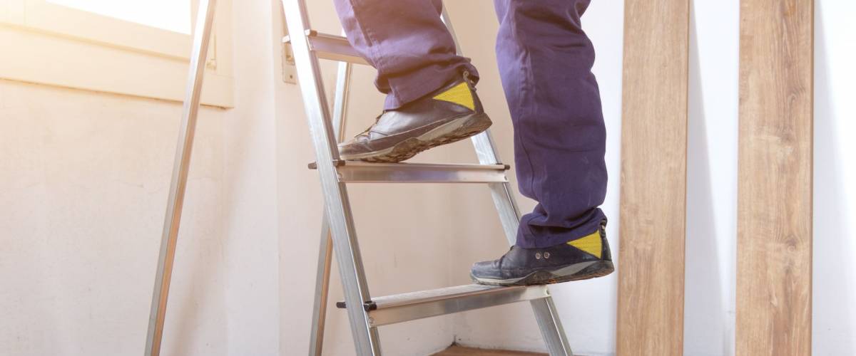 Feet of a carpenter ready for work on a ladder