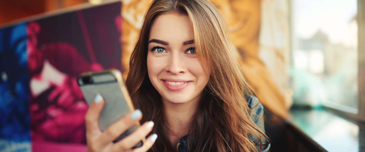 smiling young woman banking on her mobile phone