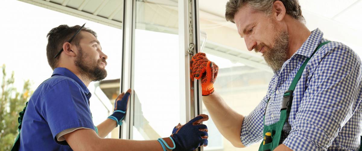 Construction workers installing new window in house