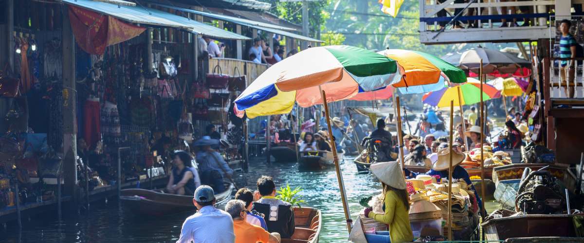 Damnoen Saduak Floating Market, tourists visiting by boat, located in Bangkok, Thailand.