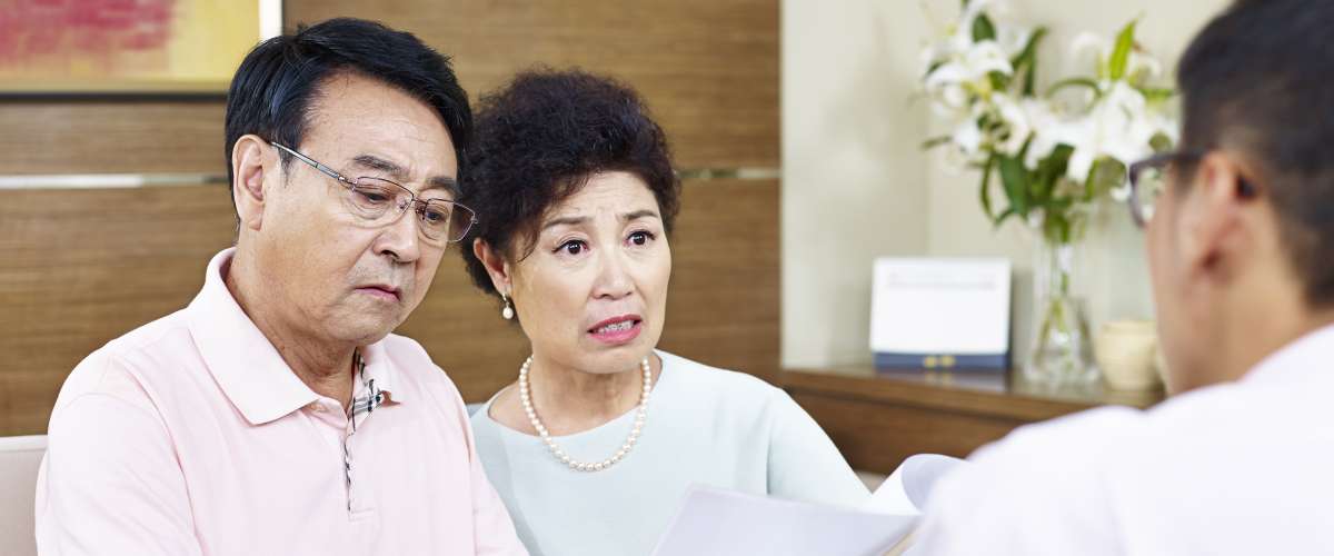 senior asian couple shocked at bank paperwork