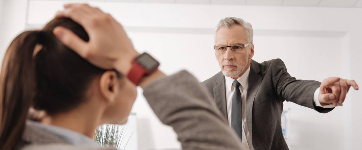 Angry boss standing opposite his secretary