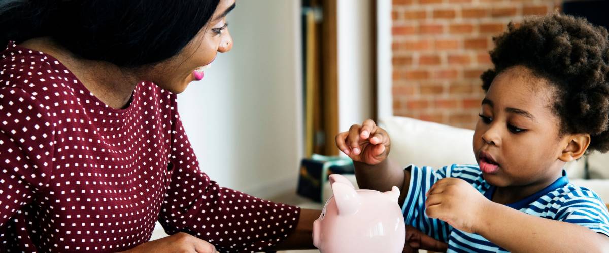 Mom and son saving money to piggy bank