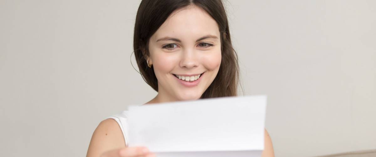 Surprised woman reading letter with unexpected good news, feeling excited about unbelievable offer in written notification, happy teenager