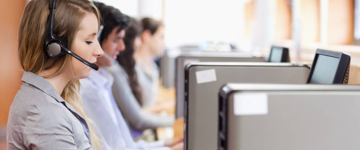 Operators using a computer in call center with the camera focus on the foreground