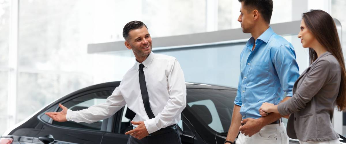 Car Salesman Invites Customers at Showroom.