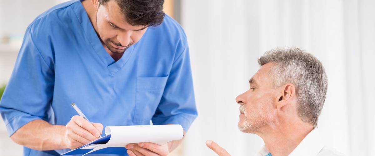 Male nurse taking care about senior patient in wheelchair.