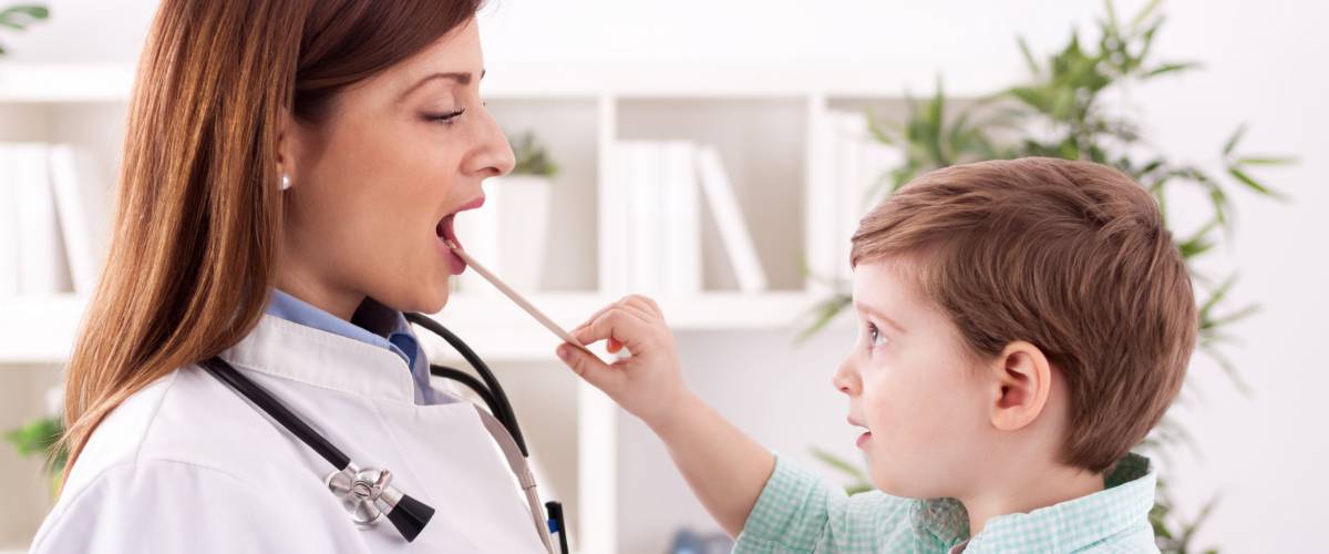 Little child playing with doctor examining in office