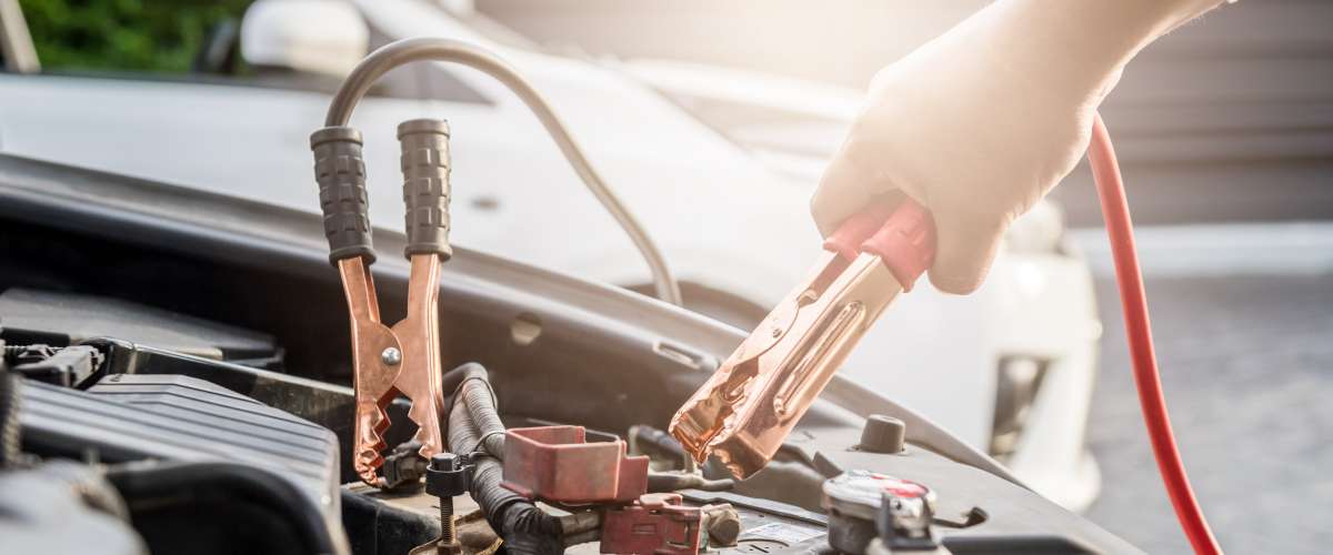 Jumper cables on a car charging battery