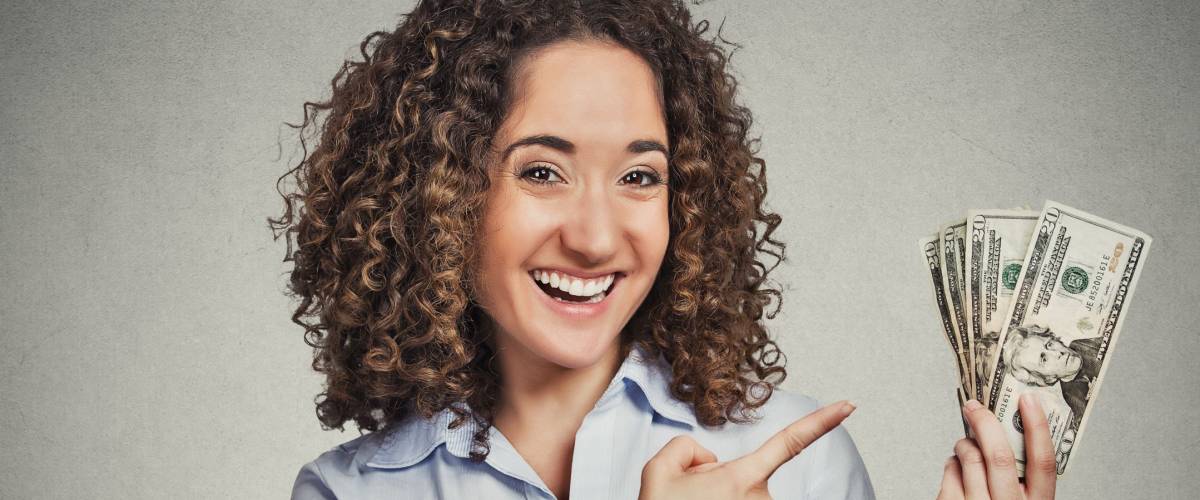 Closeup portrait super happy excited successful young business woman holding money dollar bills in hand