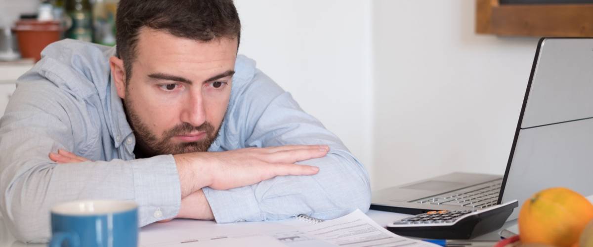Frustrated man calculating bills and tax expenses