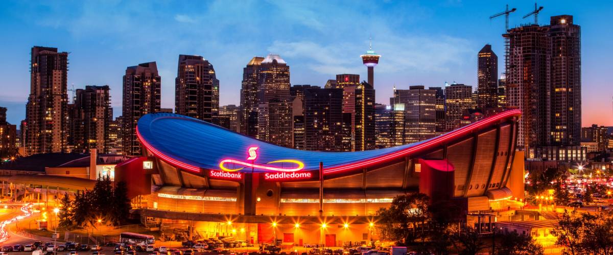 CALGARY, CANADA - MAY 23, 2015: Panorama of Calgary downtown skyline at sunset blue hour showing the iconic Scotiabank Saddledome and Calgary Tower with surrounding city skyscrapers.