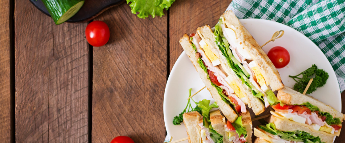 Club sandwich with cheese, cucumber, tomato, ham and eggs