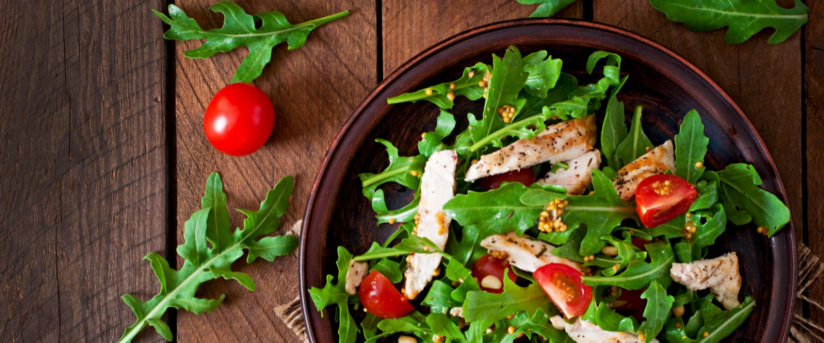 Fresh salad with chicken breast, arugula and tomato