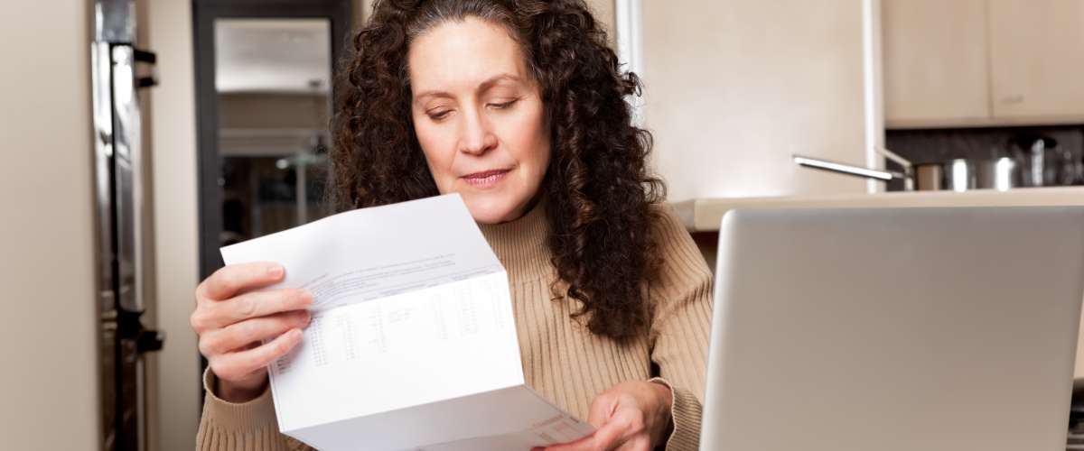 middle aged woman paying bills at home