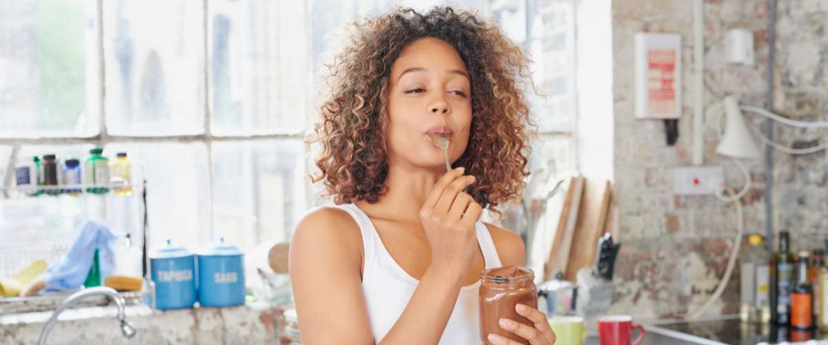 young woman eating at home in her kitchen