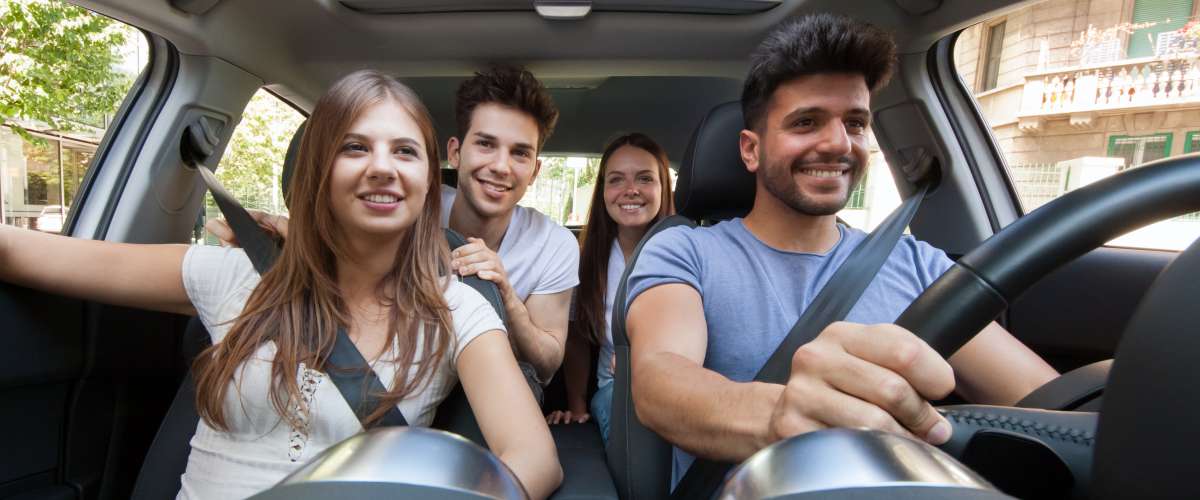 Group of happy young friends in a car