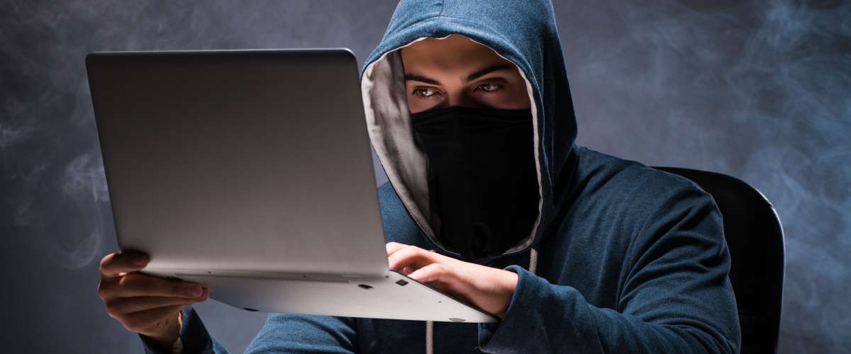 Computer hacker working in a dark room