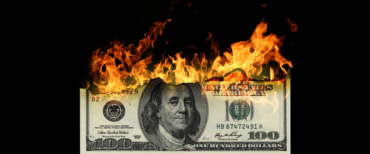$100 American bill set on fire and burning