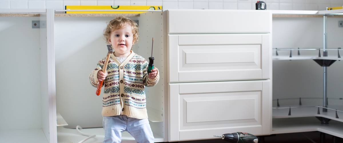 young child helping to install kitchen in family home