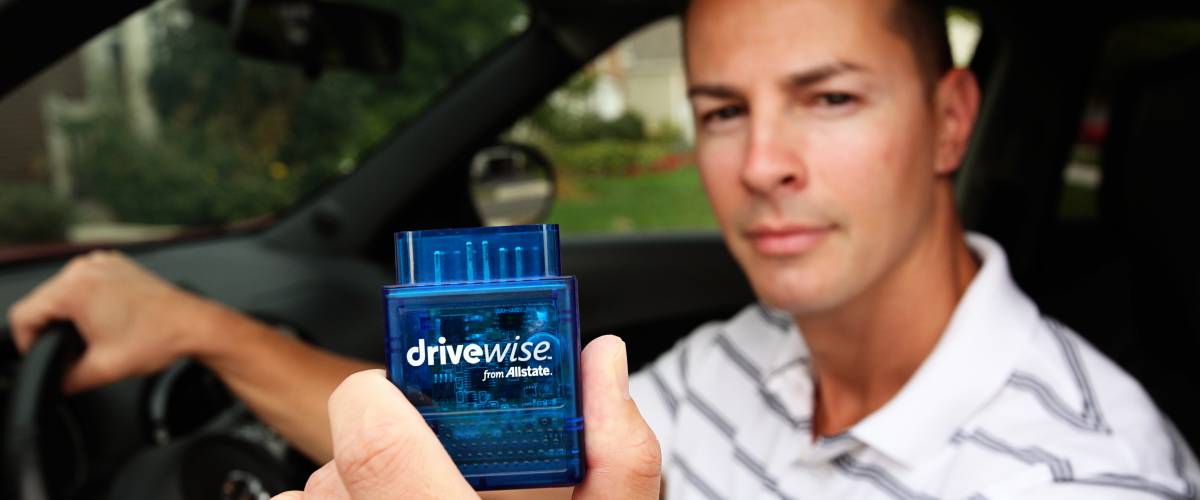 Young man holding the Allstate Drivewise dongle