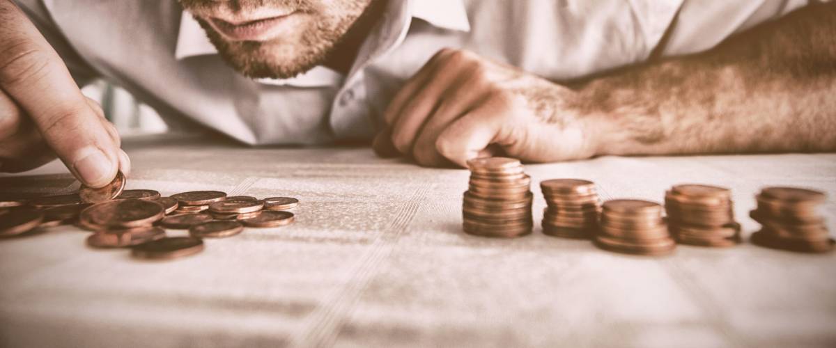 Young man counting coins on a table