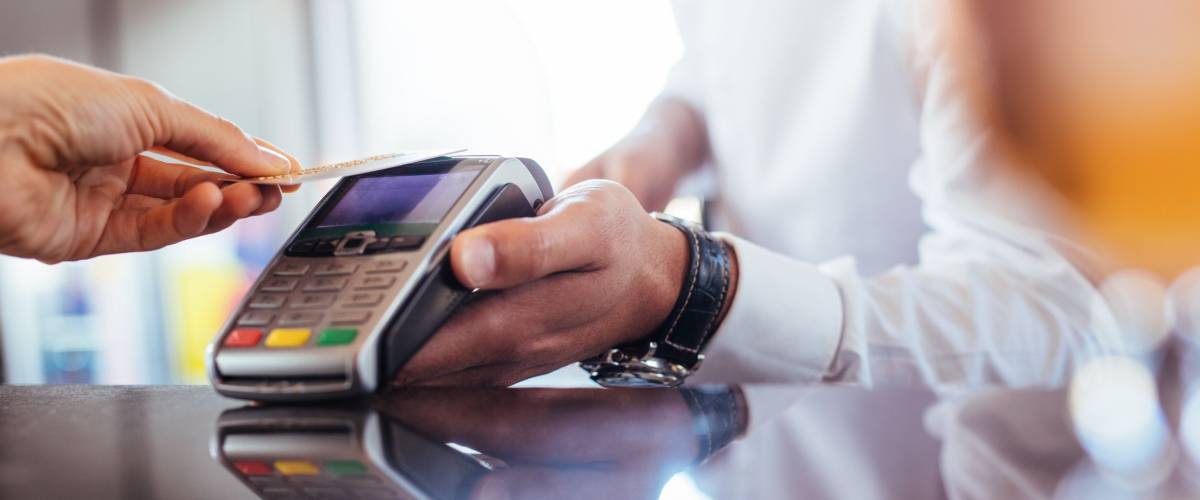 Hand of customer paying with contactless credit card