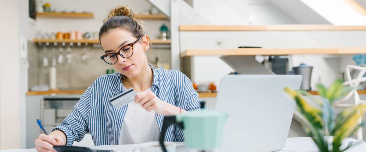 Young woman paying bills online with credit card