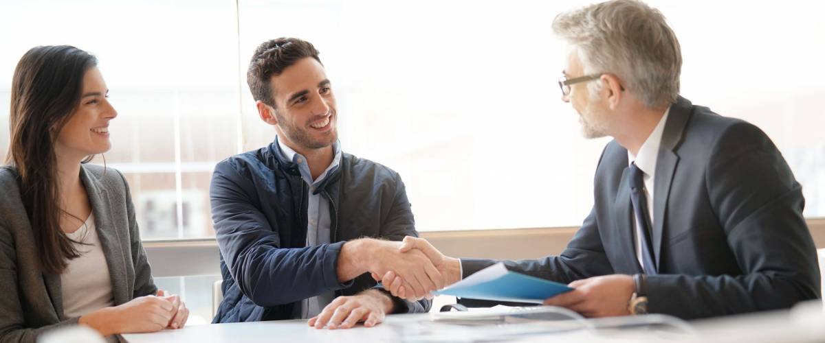 Young couple meeting financial advisor for investing.