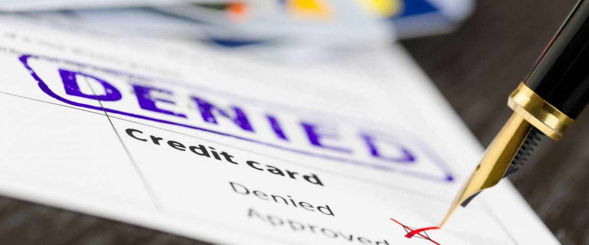 Credit card form close up, fountain pen and denied stamped on a document.
