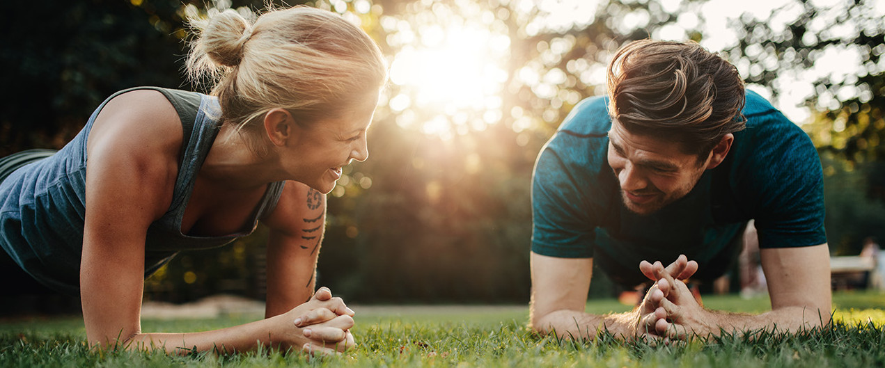 Young couple doing core exercises in the park