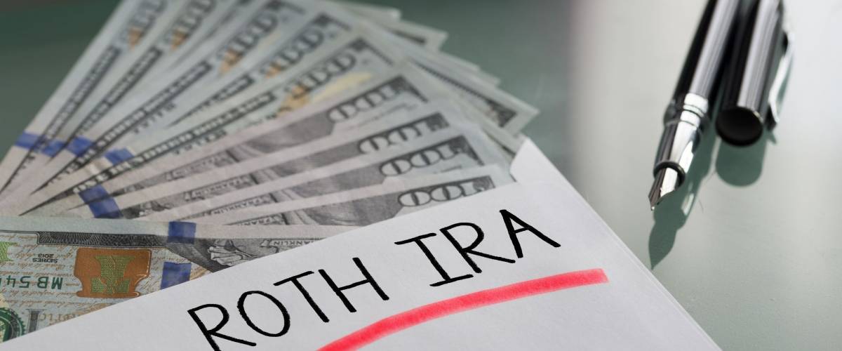 Savings for retirement concept with Roth Ira written on white envelope with cash US dollars
