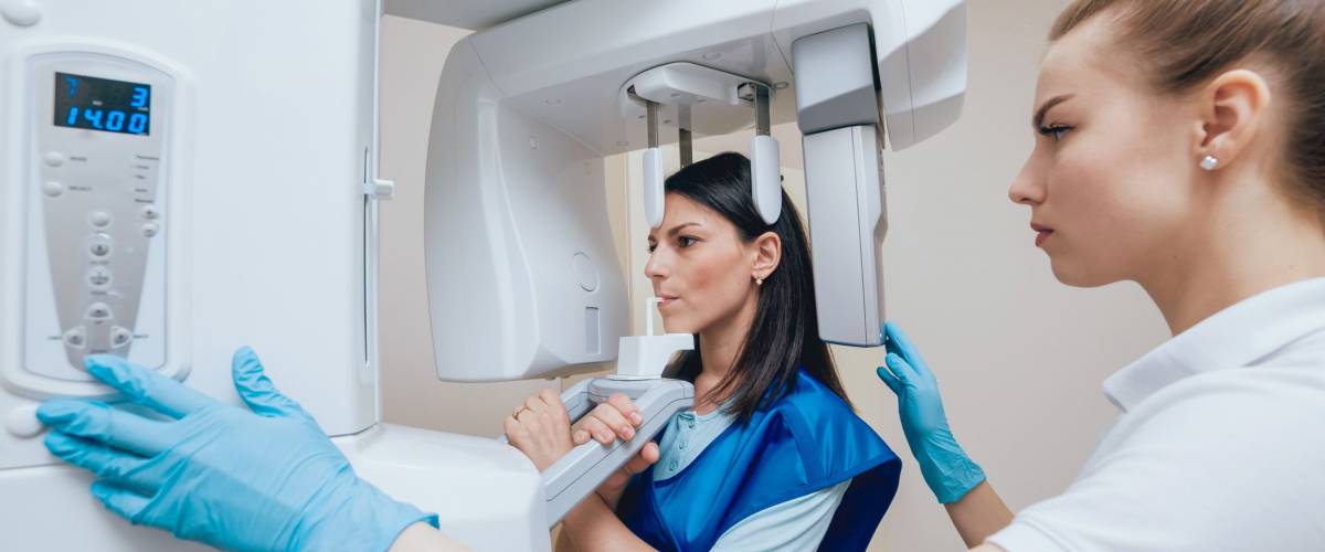 Young woman patient standing in x-ray machine. Panoramic radiography