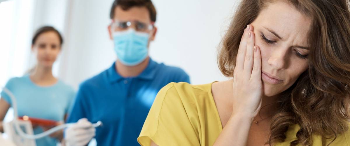 Female patient having toothache at dentist's surgery.