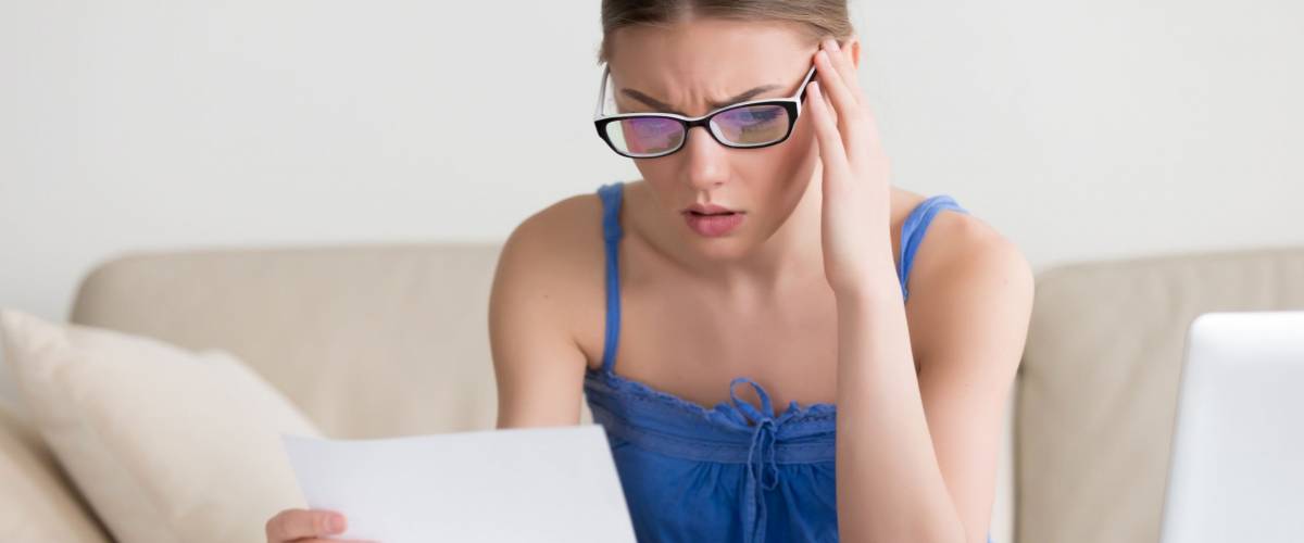 Worried woman reading negative news in letter
