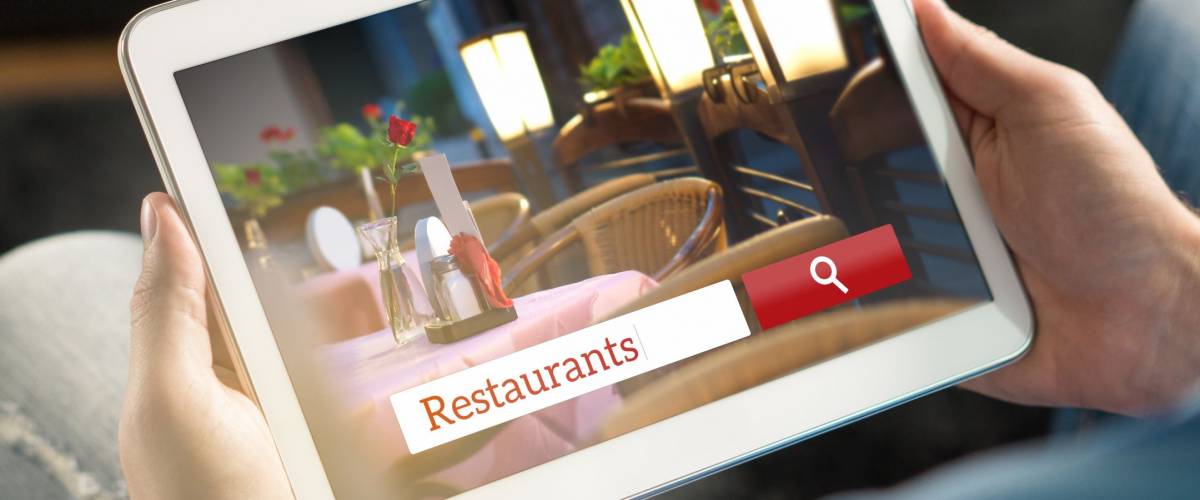 Man using tablet trying to find the perfect restaurant from review website or application. Tavern, cafe or bistro search engine and app online. Rating social media on internet.