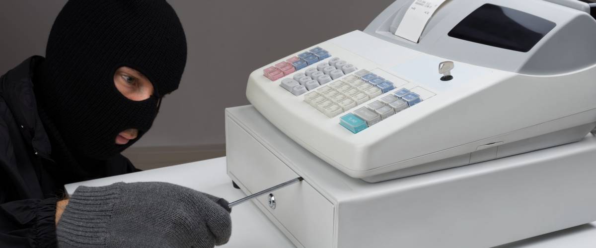 Close-up Of Thief Opening Cash Register Drawer With Screwdriver