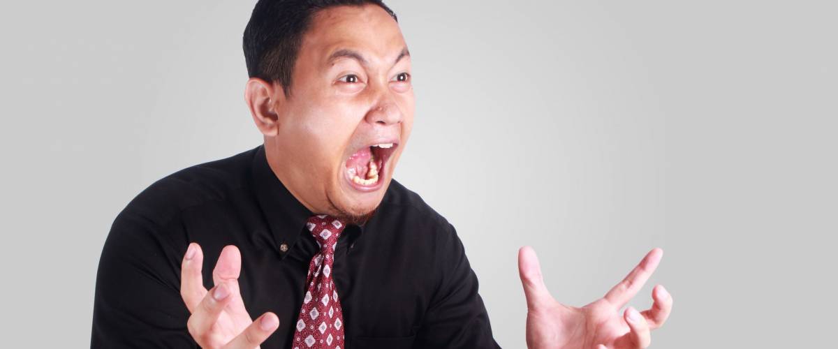 Portrait of young Asian businessman manager shows angry facial expression, mad boss screaming bad business concept