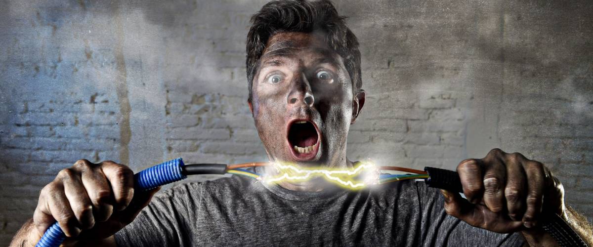 electrocuted man holding electrical cable with black soot on his face
