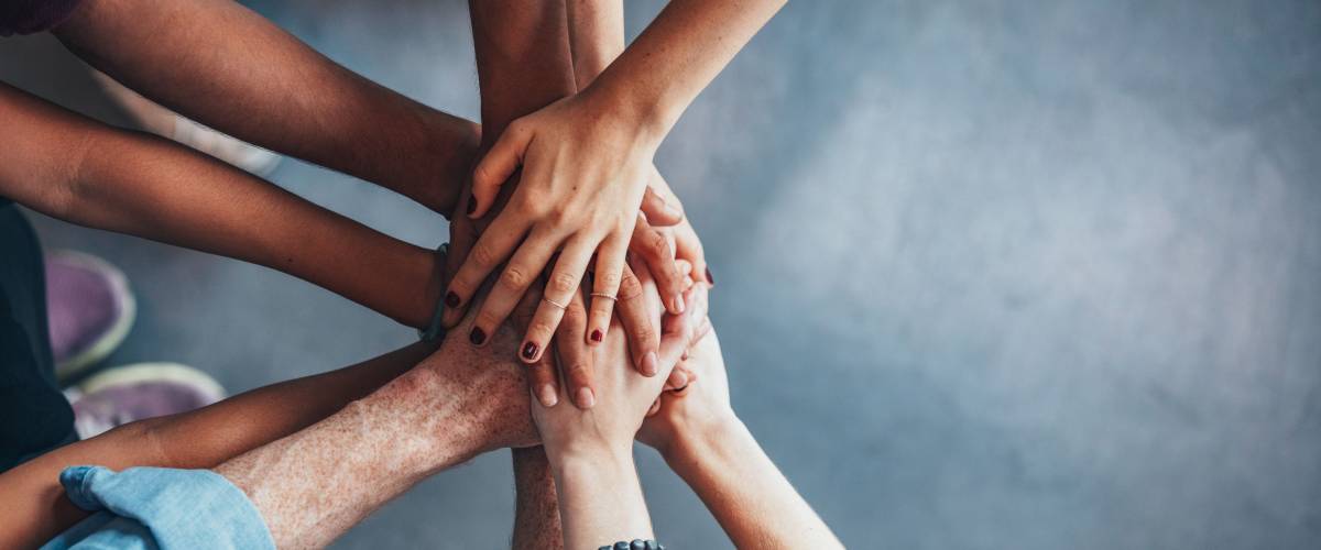 people putting their hands together in a huddle