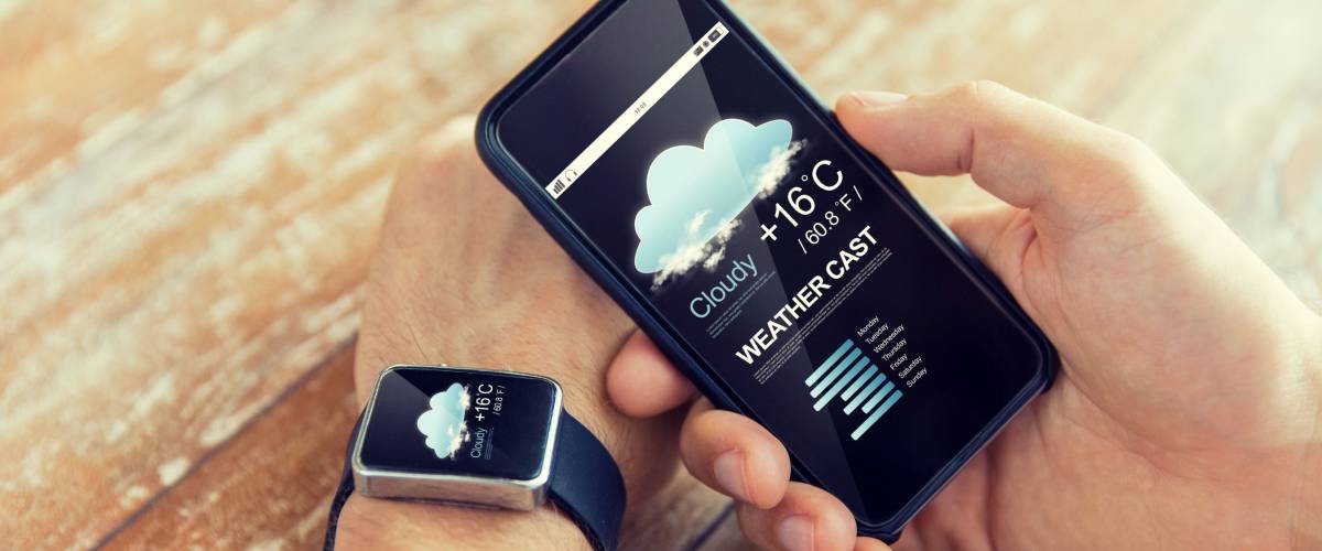man looking at weather forecast on smartphone and Apple watch