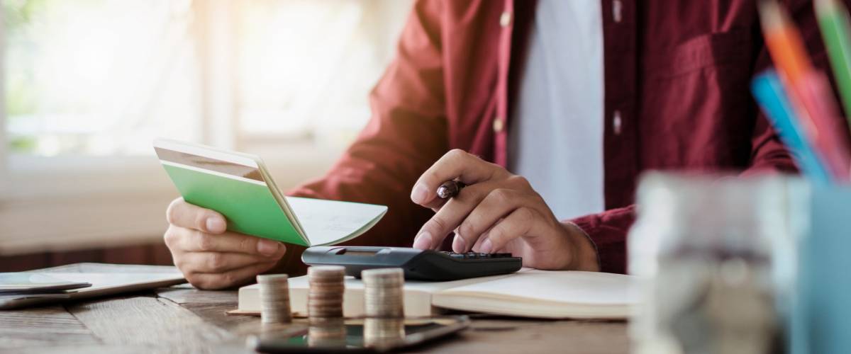 Business man hands holding saving account passbook with calculator, account and saving concept.
