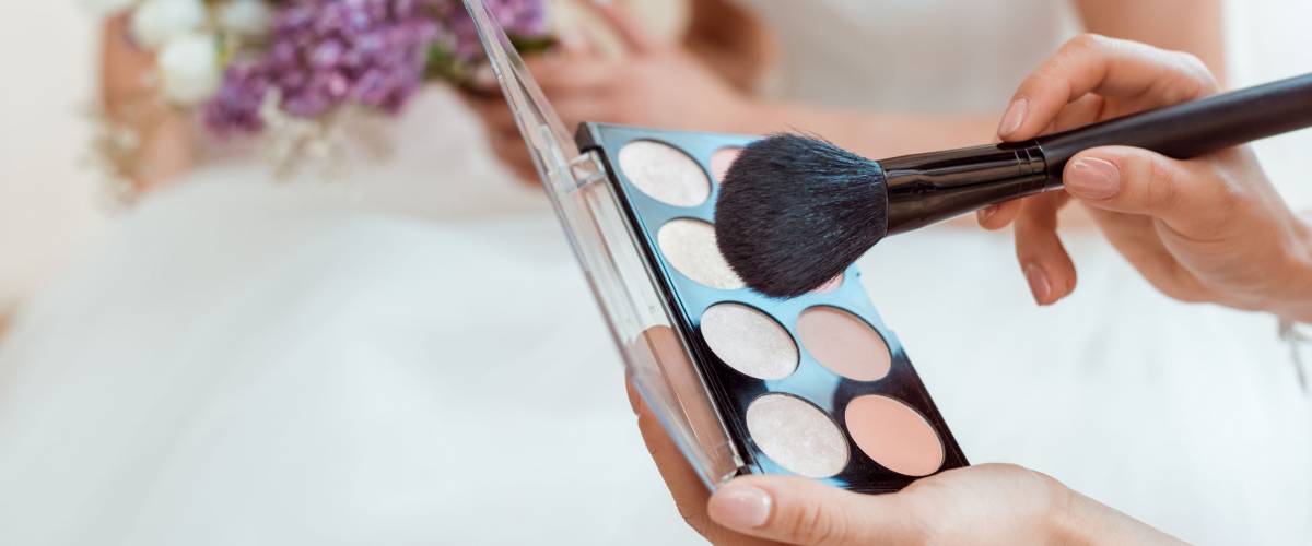 cropped shot of wedding makeup artist with powder