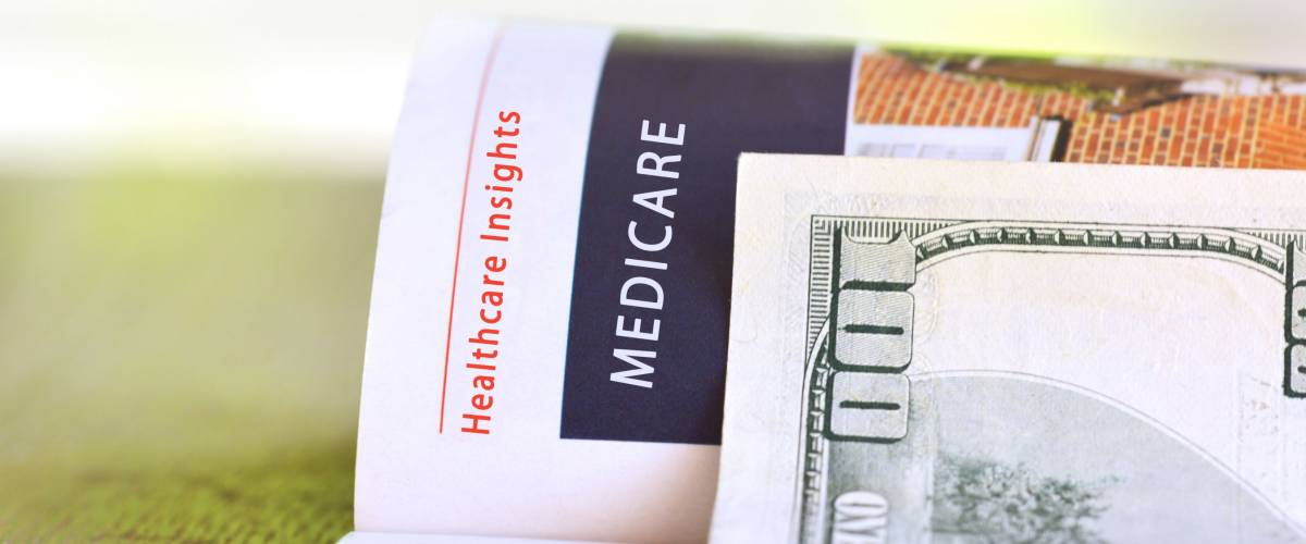 Medicare paper headline with hundred dollar bill