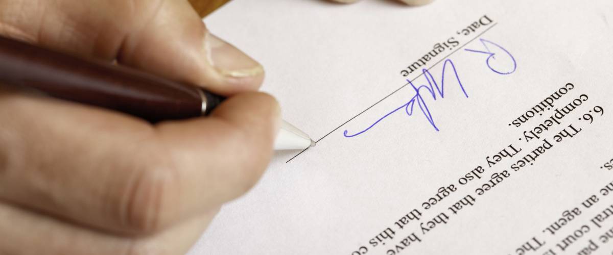 Closeup of hands signing a contract