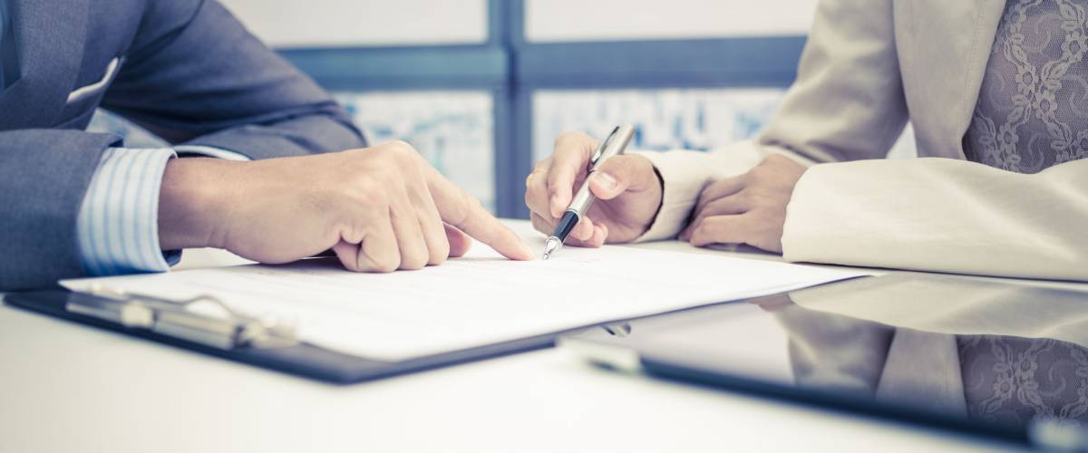 Female hand signing contract.