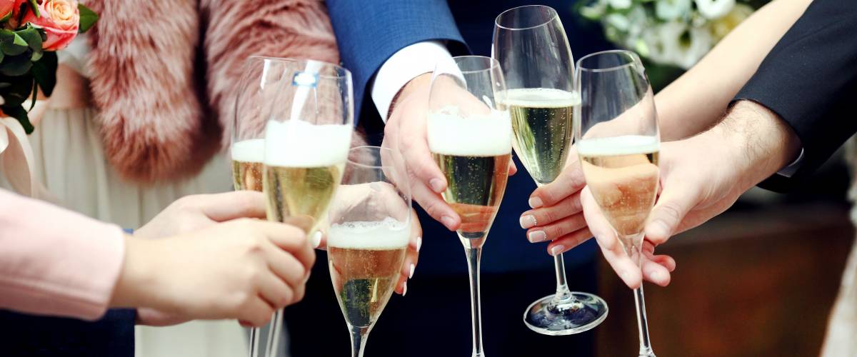 friends toasting at a wedding close up of champagne flutes
