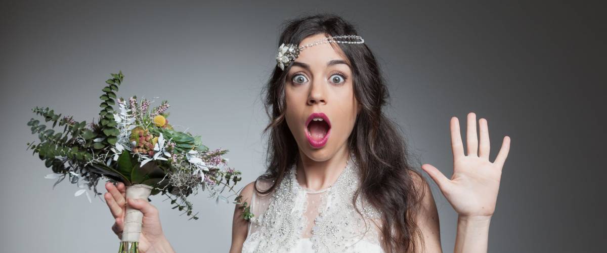 Surprised bride holding flowers bouquet