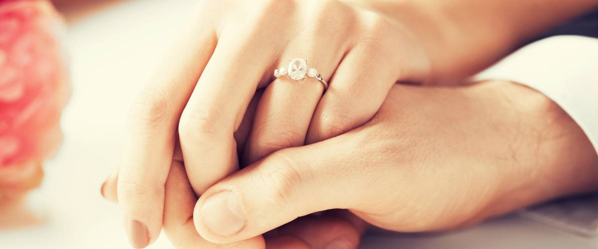 up close engagement ring man and woman holding hands